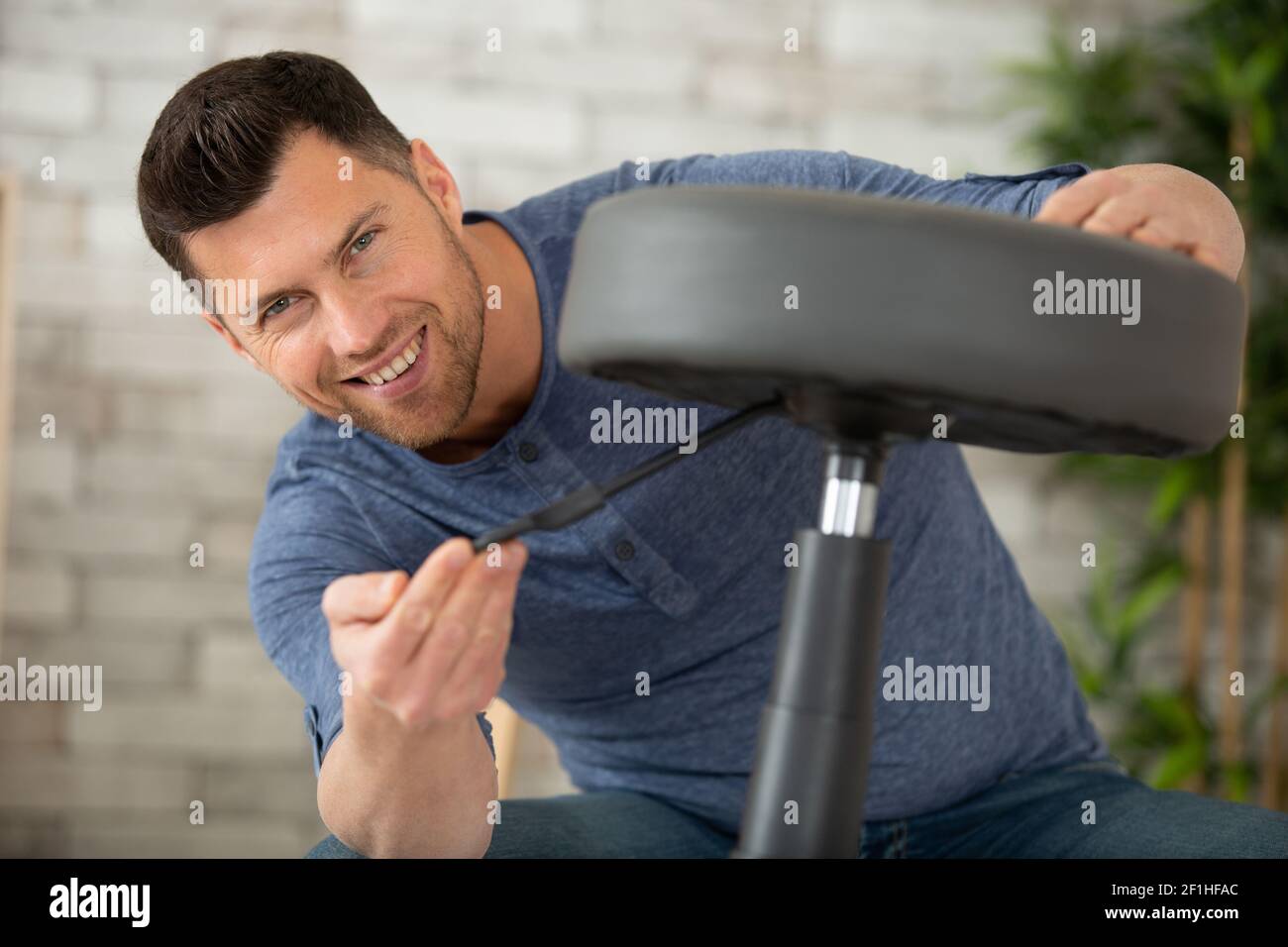 man adjusting stool chair at home Stock Photo - Alamy