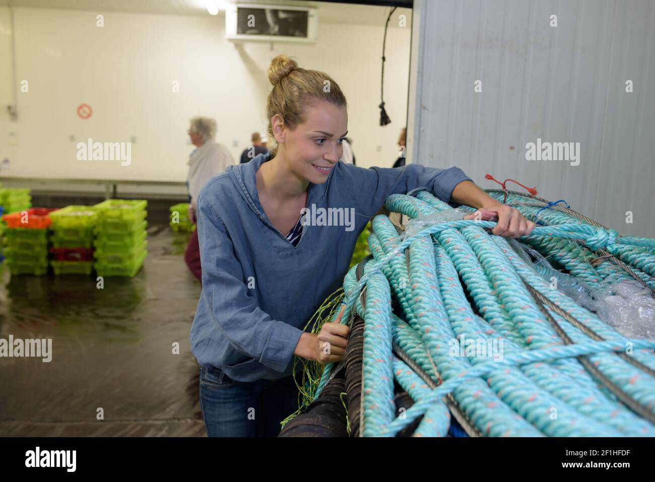 woman securing bundle of rope in fish factory Stock Photo - Alamy