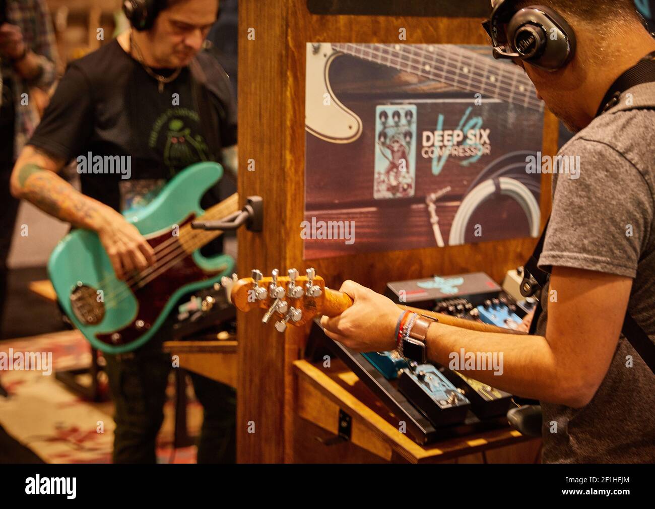 Attendees musicians testing playing guitar pedals at Musical Instrument Convention Stock Photo