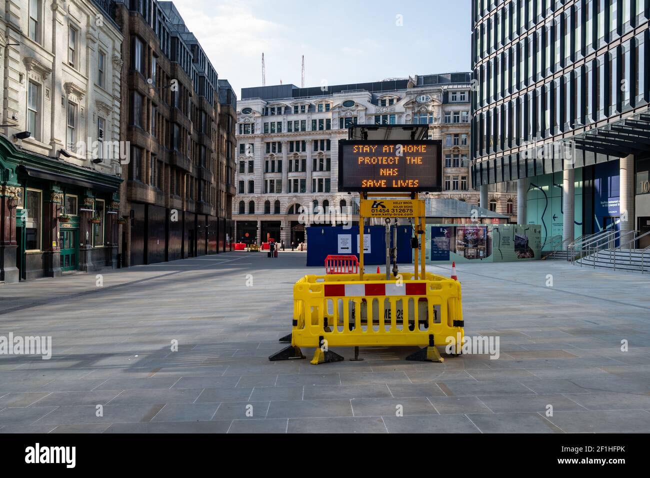 Liverpool Street, London. Covid pandemic, third lockdown. An illuminated display of 'Stay at home, protect NHS, Save Lives' against an empty street. Stock Photo