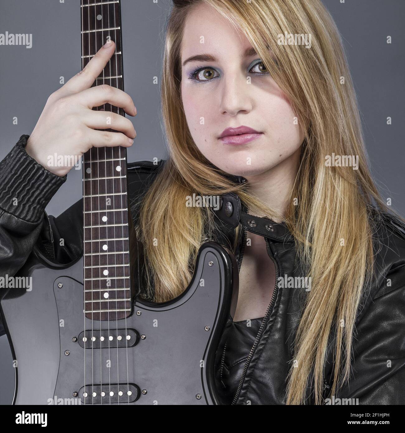 Pretty and beautiful blonde with black electric guitar Stock Photo