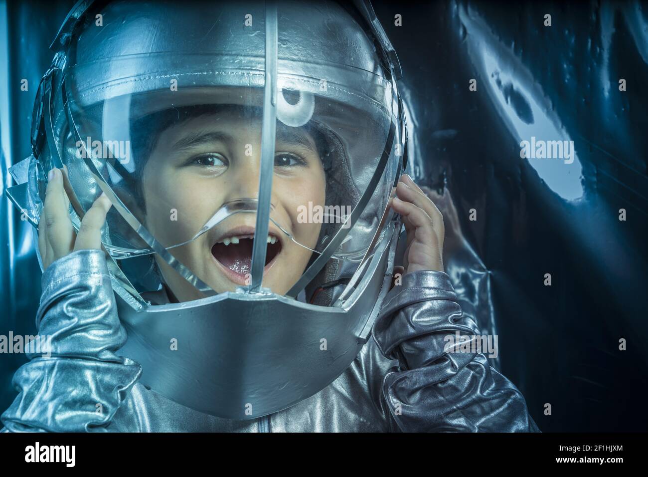 Game, Boy playing to be an astronaut with space helmet and metal suit