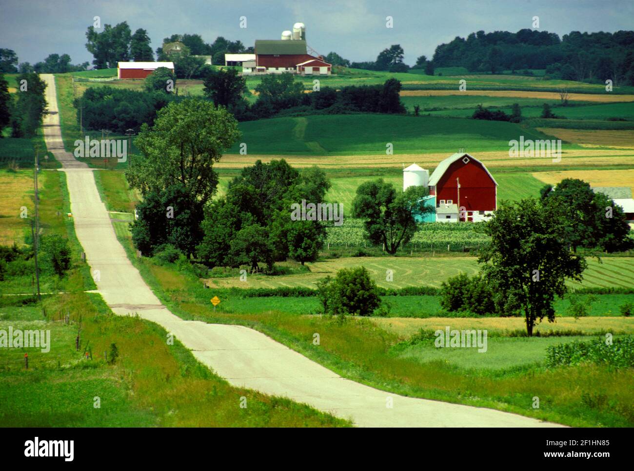 The country road through farmland with crops, barns, and houses in Elsworth Wisconsin the United States America USA Stock Photo
