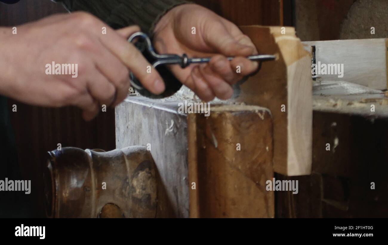 Close up, carpenter makes a hole by using tip turning loving Stock Photo
