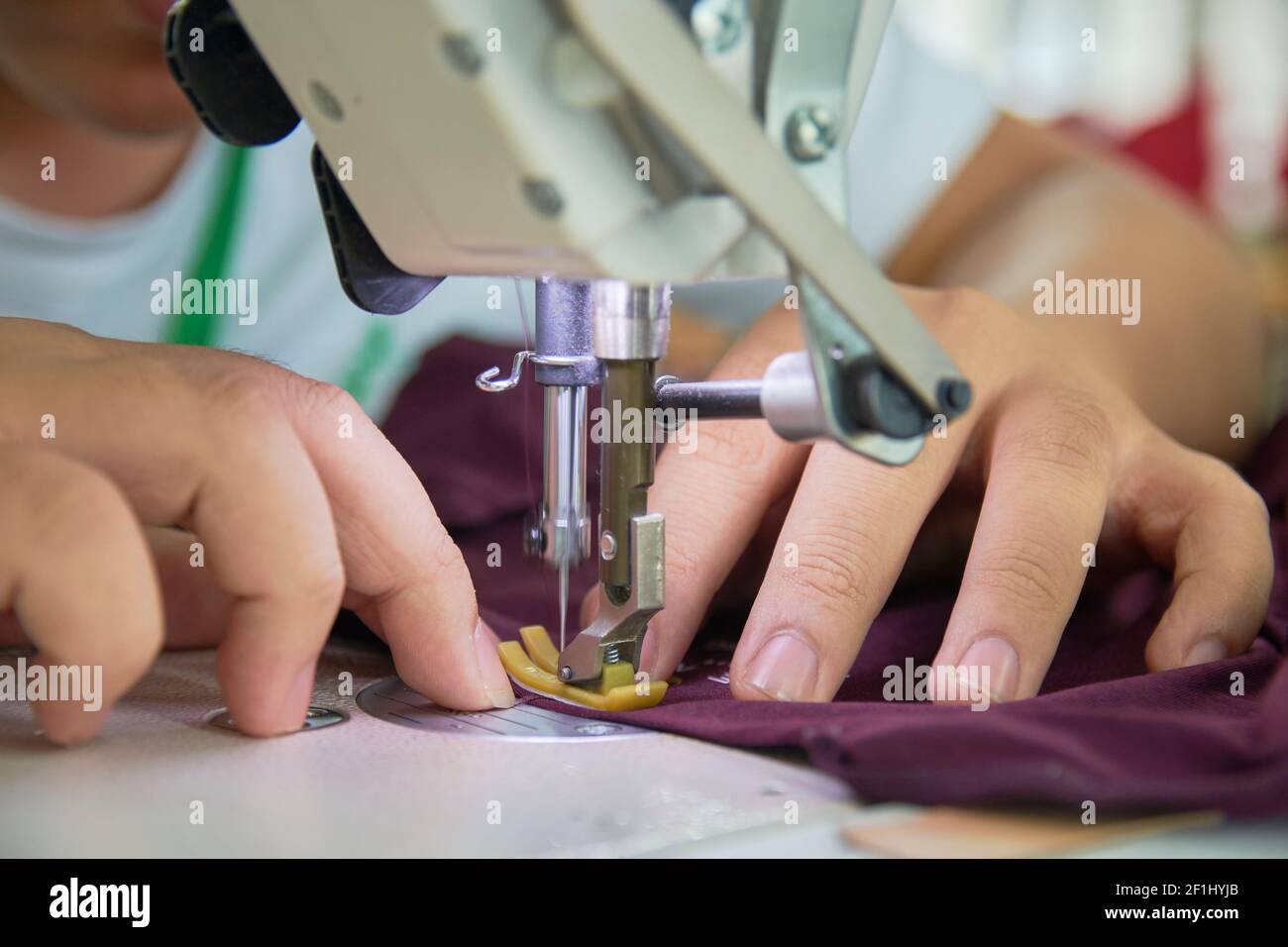 Employee's hands working with his sewing machine in clothing factory Stock Photo