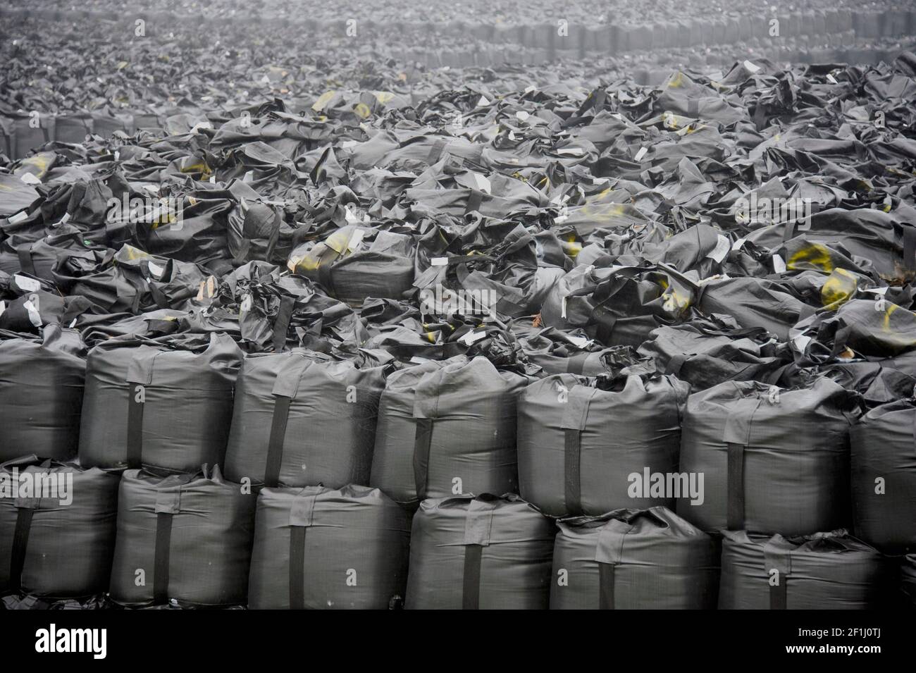 Photo shows tens of thousands of bags of nuclear contaminated soil and weeds that have been stacked on a temporary storage zone near Fukushima Daiichi Nuclear Power Plant in Okuma, Fukushima Prefecture, Japan in June 2013. Today thousands of these disposal sites can be found dotted around the prefecture and decontamination efforts, as well as decommissioning of the nuclear plant, continue. Photographer: Robert Gilhooly Stock Photo