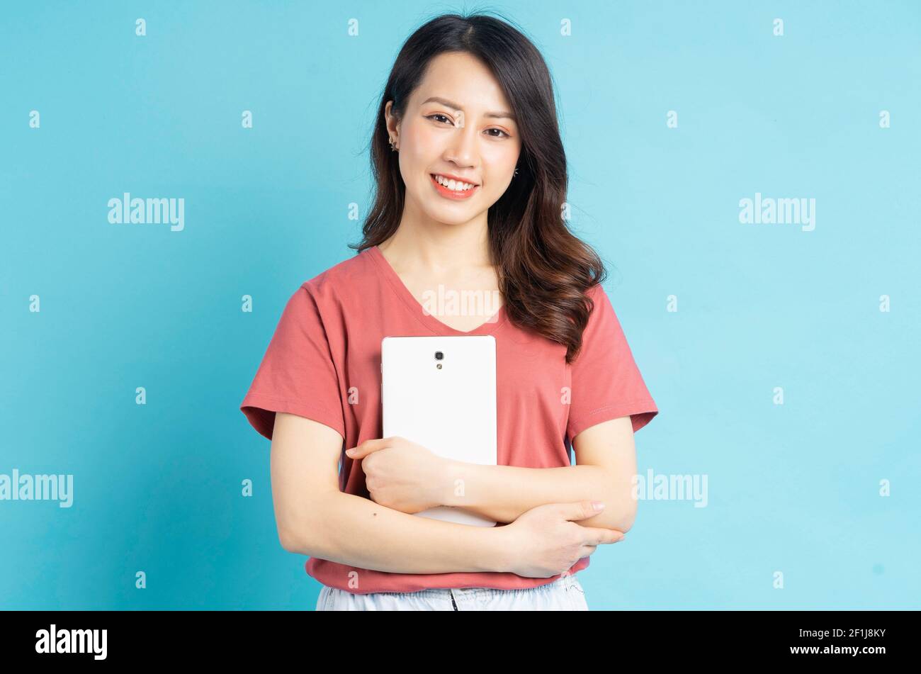 Beautiful Asian woman smiling holding tablet computer Stock Photo - Alamy