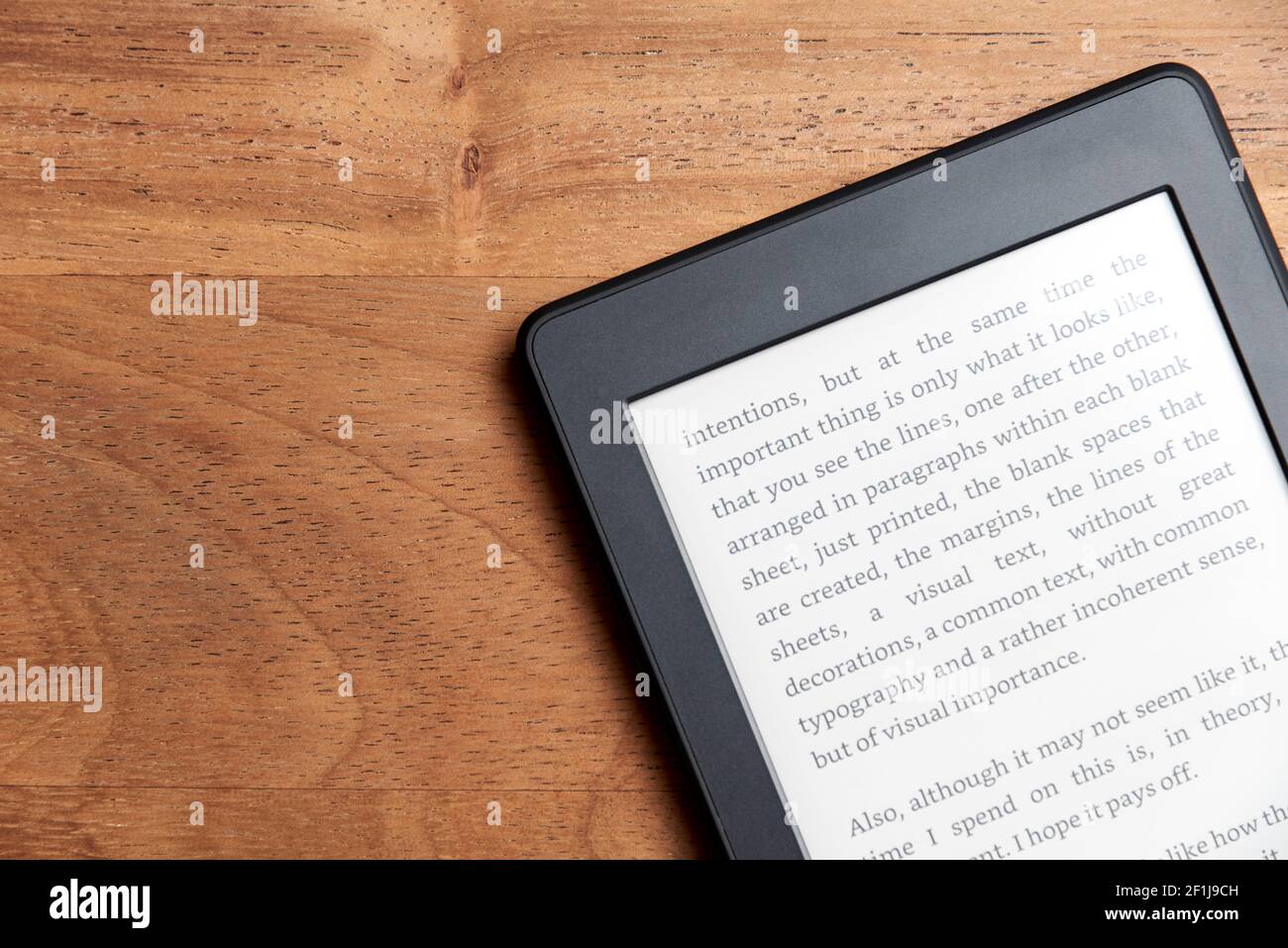 Closeup image of an electronic reader with blank screen on a wooden surface. Concepts of technology and modernity. Image with copy space. Stock Photo