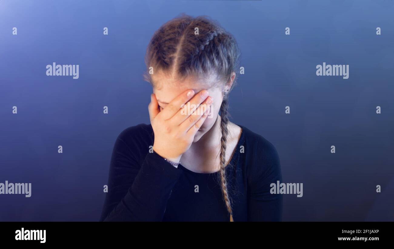 Teenage girl with pigtails, being attacked by social media, creating emotional stress Stock Photo