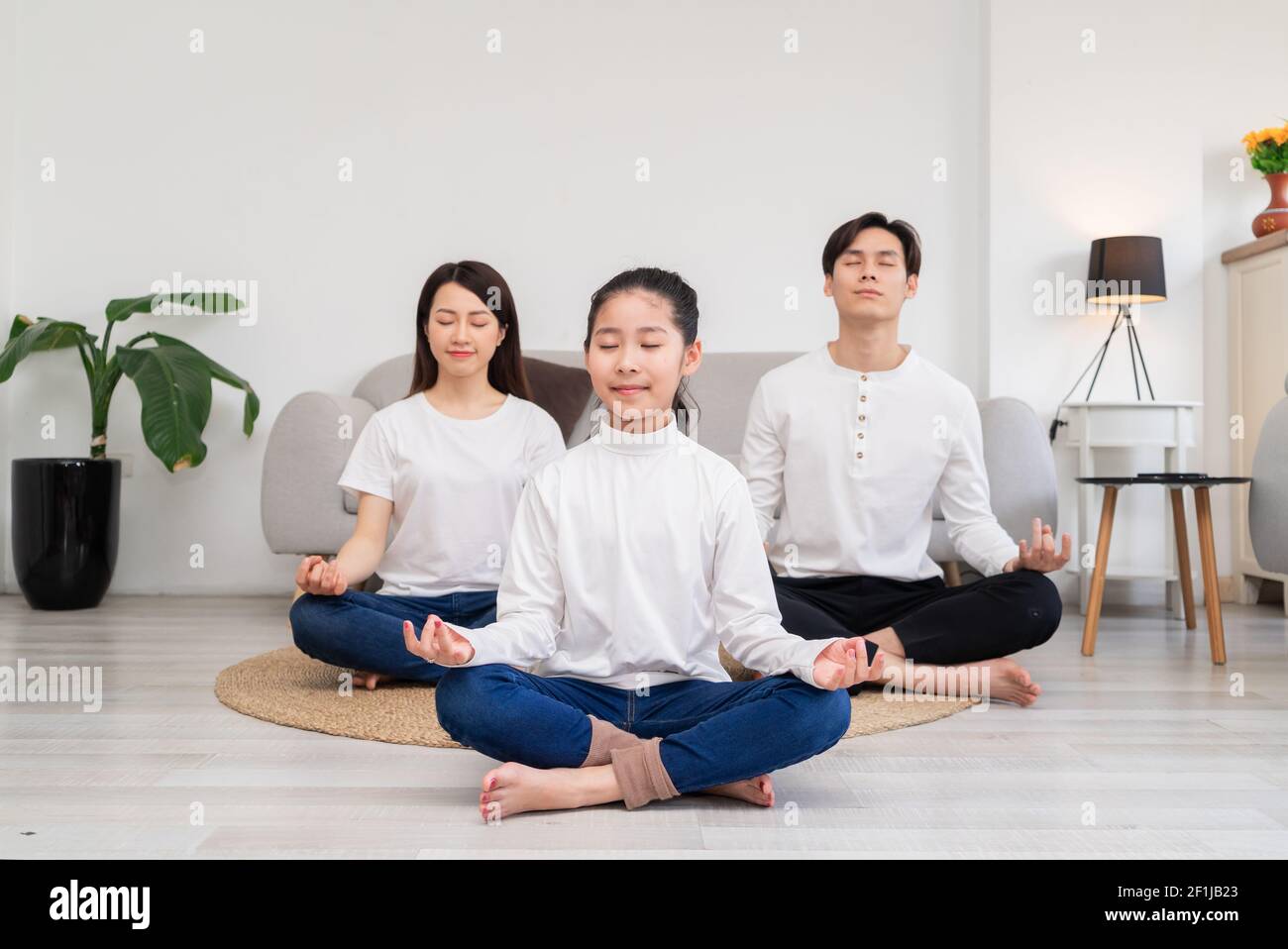 Young Asian family doing exercise together at home Stock Photo