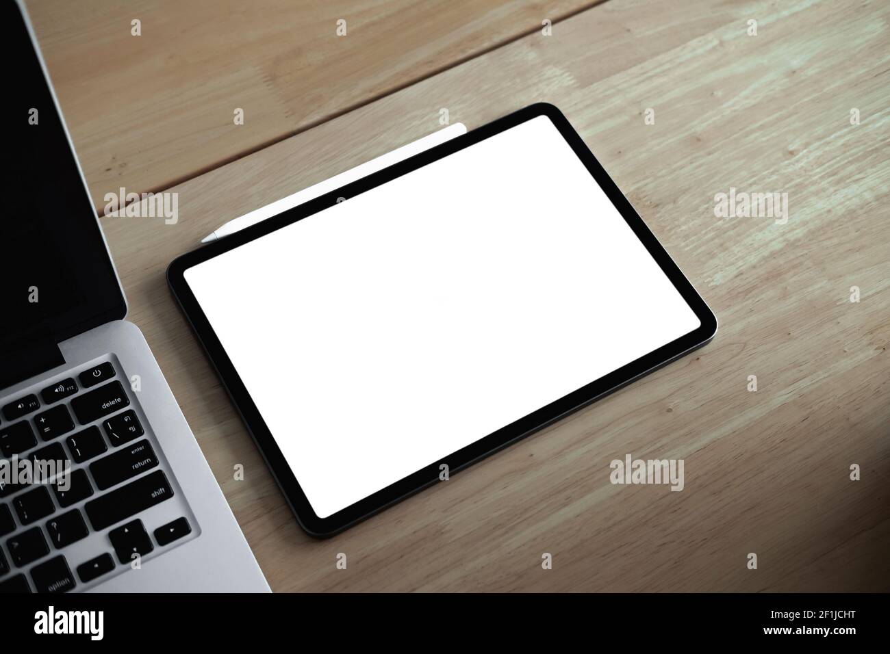 Cropped shot of mock-up digital tablet with blank white screen on desk. Stock Photo