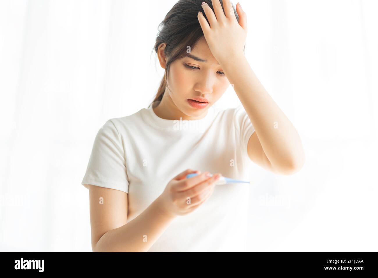 Young girl is measuring herself temperature Stock Photo - Alamy