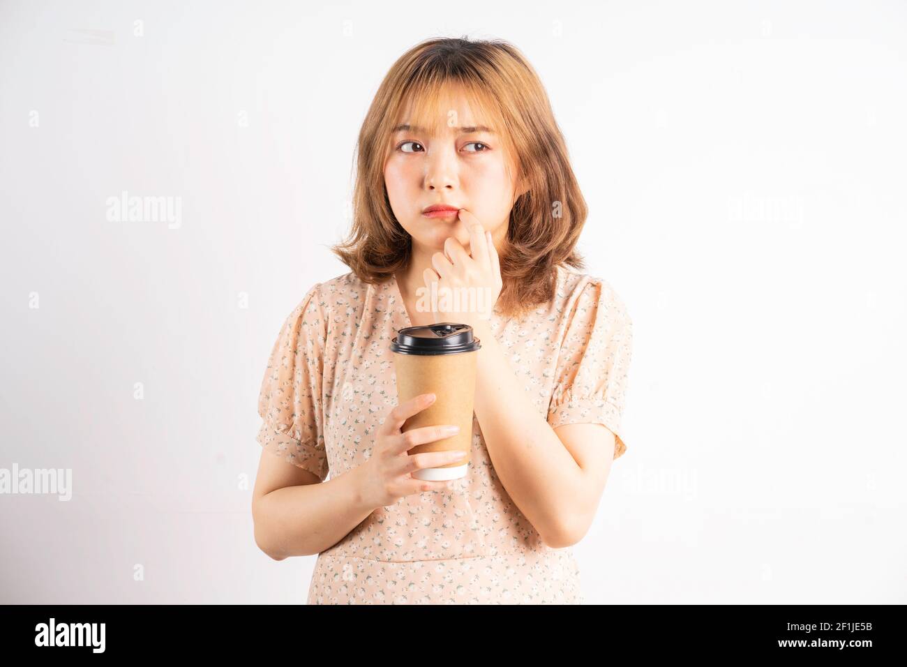 Young asian girl holding coffee cup with expression on background Stock Photo