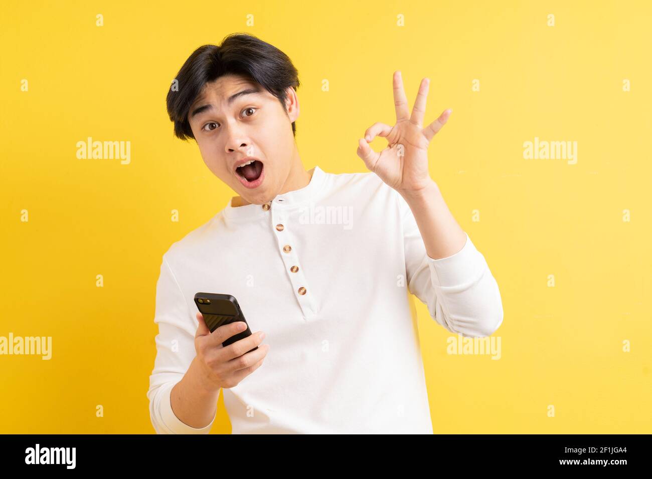 Asian man using his phone with a surprised face Stock Photo