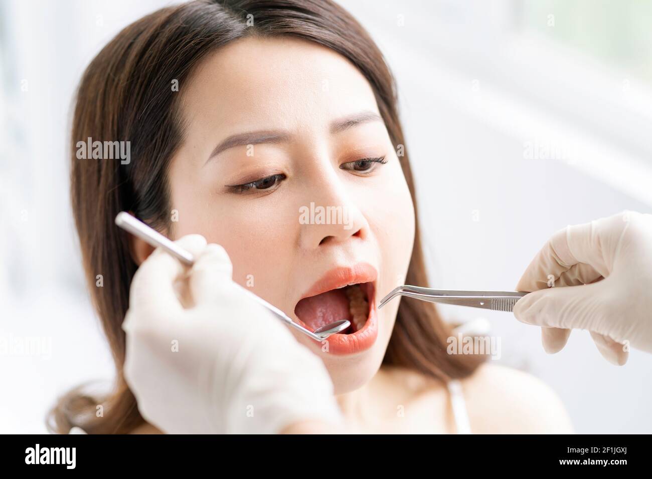 The Asian woman is having a routine dental exam at the dental clinic Stock Photo
