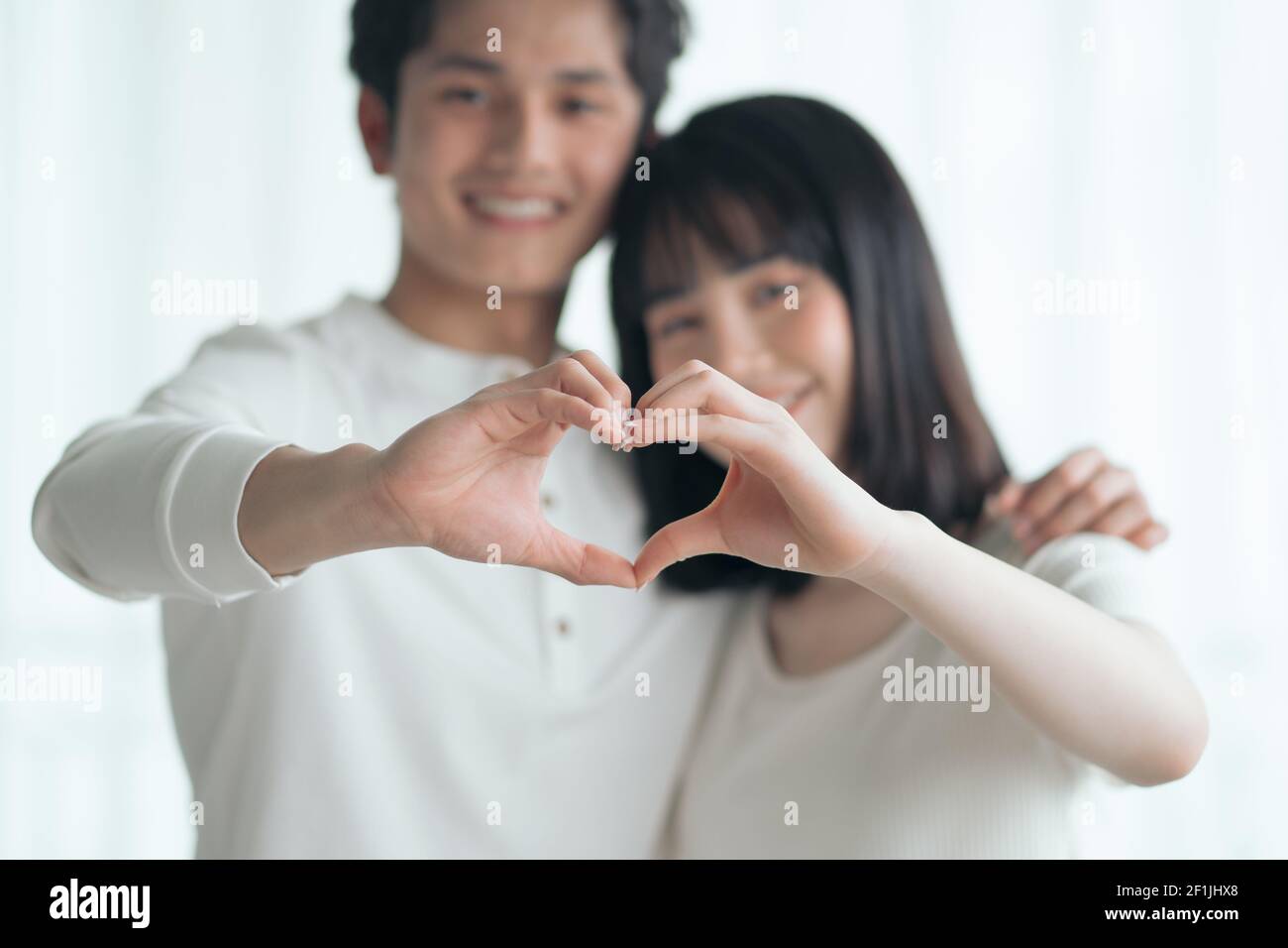 Asian couple making a hand-drawn heart shape together Stock Photo - Alamy