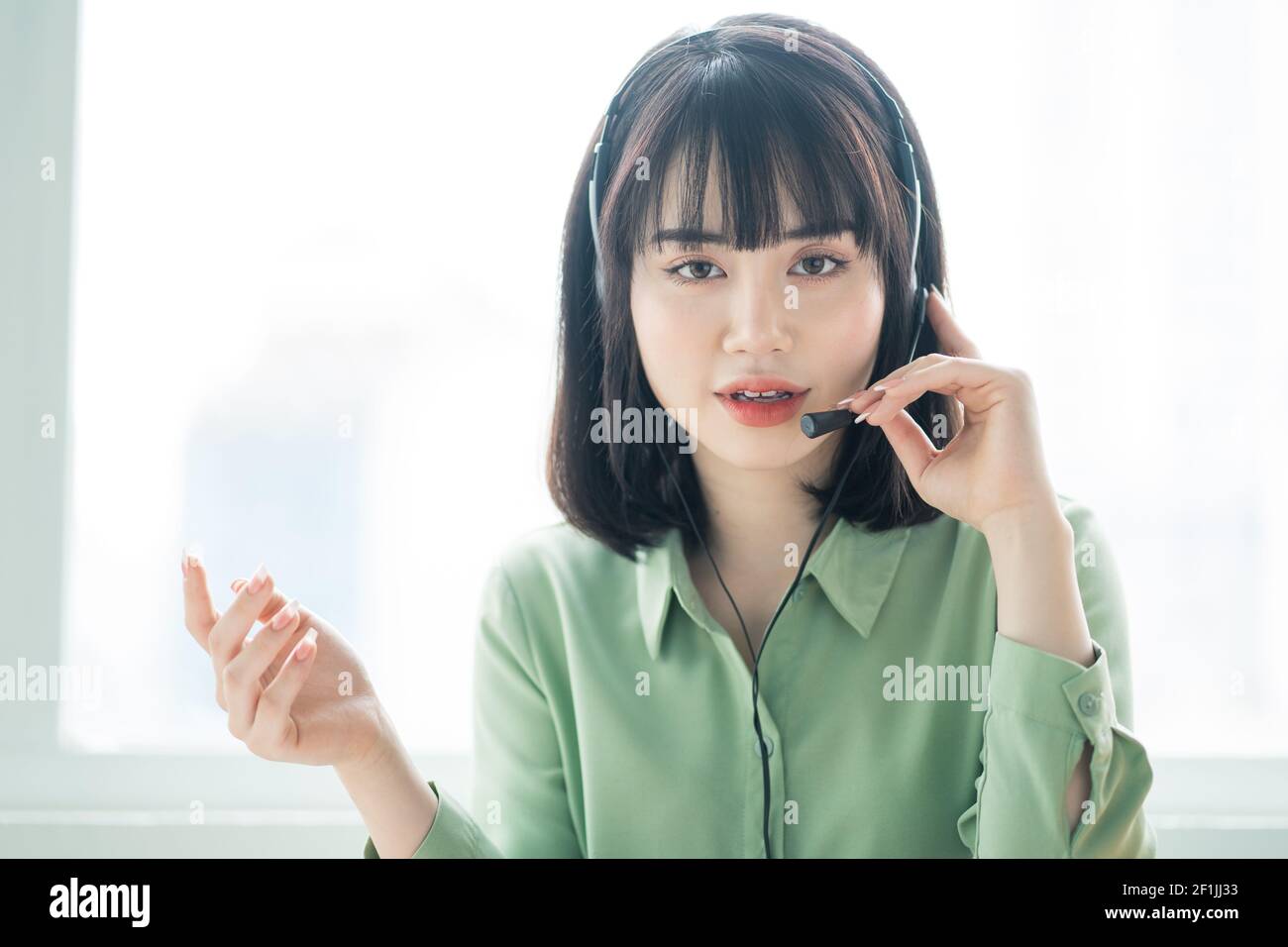 Beautiful asian customer service lady is calling customers to offer ...