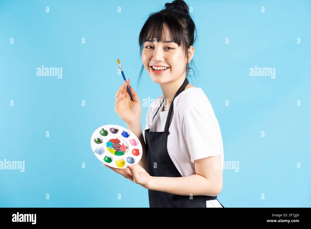 Beautiful Asian female painter holding quill pen and color palette on ...
