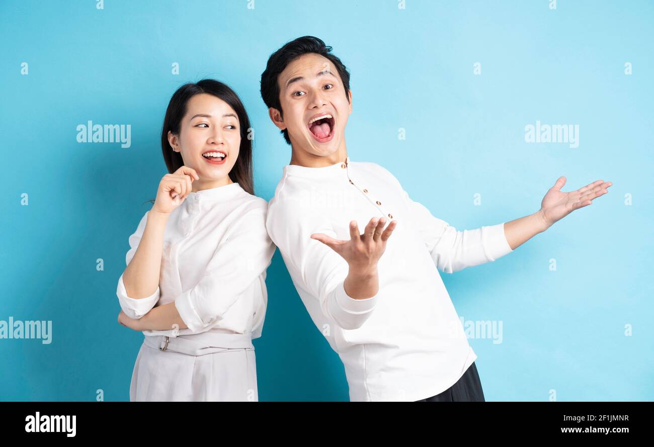 Portrait of young couple standing posing on blue background Stock Photo ...
