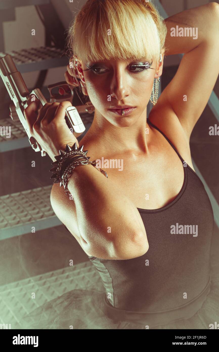 Cyberpunk, Blonde girl with pistols in an abandoned factory. cosplayer, action and dangerous woman Stock Photo