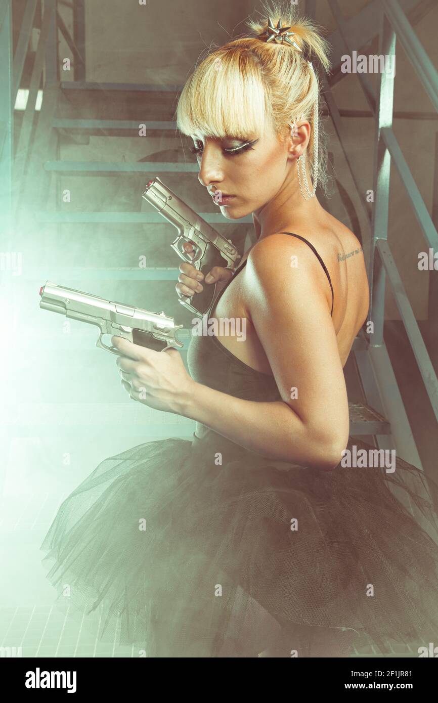 Cosplay, Blonde girl with pistols in an abandoned factory. cosplayer, action and dangerous woman Stock Photo