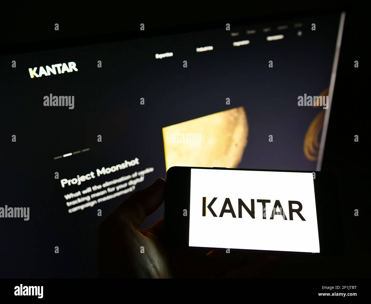 Person holding mobile phone with logo of British market research company  Kantar Group Limited on screen in front of web page. Focus on phone display  Stock Photo - Alamy
