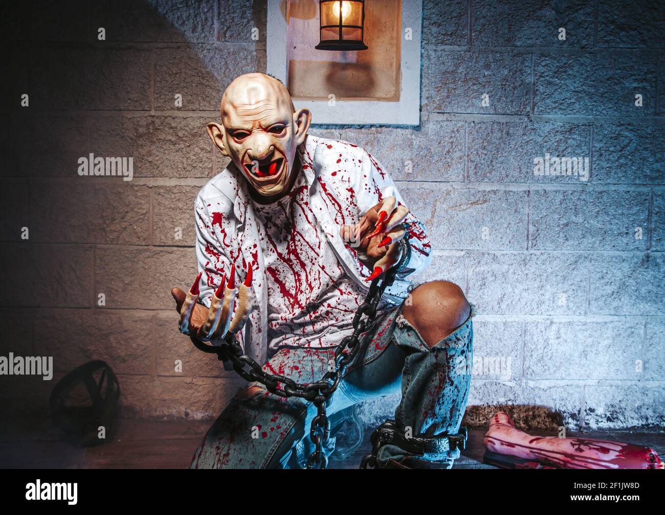 Halloween costume, Man chained with blood and knife, Zombie man death the ghost horror drain hand blood skin is screaming darkne Stock Photo