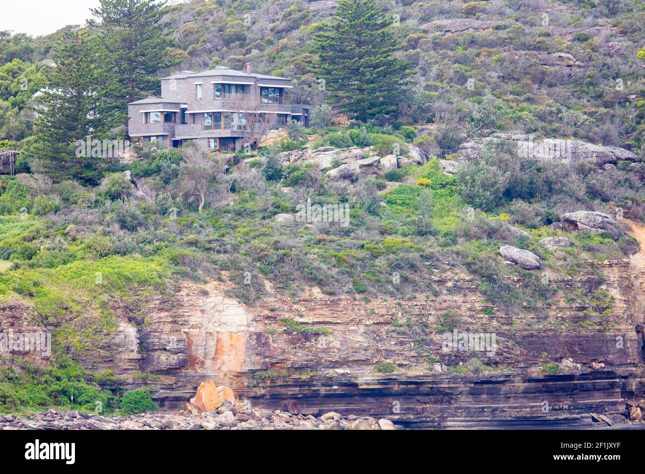 Rock cliff erosion below a Sydney home on the headland at Avalon Beach in Sydney,NSW,Australia, coastal erosion and climate change Stock Photo