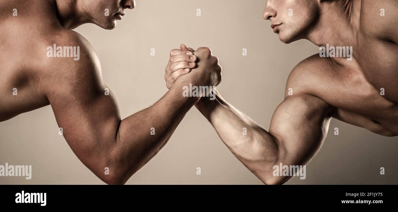 Two hands. Muscular men measuring forces, arms. Hand wrestling, compete