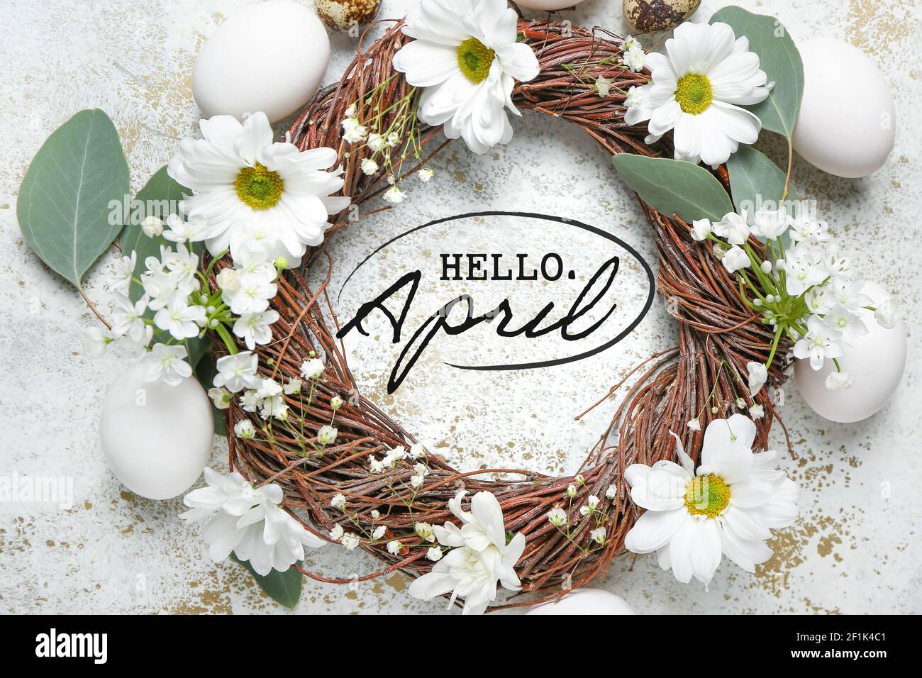 Composition with Easter eggs and spring flowers with text HELLO APRIL on light background Stock Photo