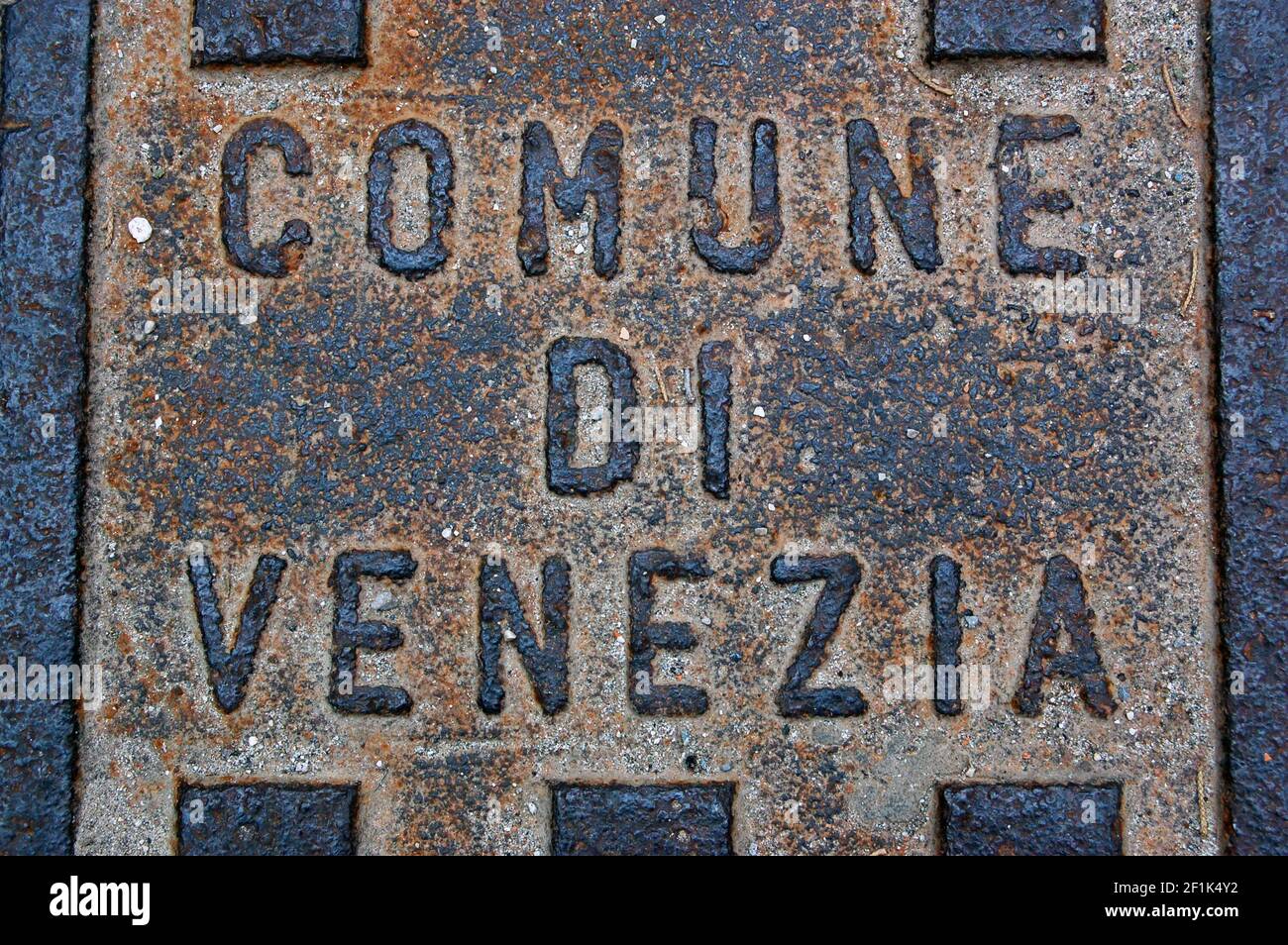 A rusty cast iron manhole cover over a drain in Venice, Italy. Stock Photo