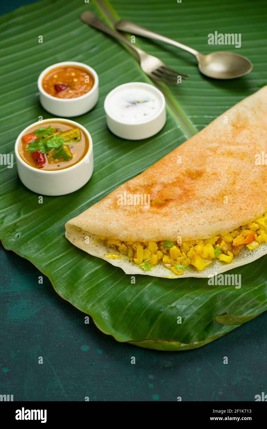Dosa  Masala dosa,famous south Indian breakfast item which is made in caste iron pan in traditional way and arranged on a fresh banana leaf. Stock Photo