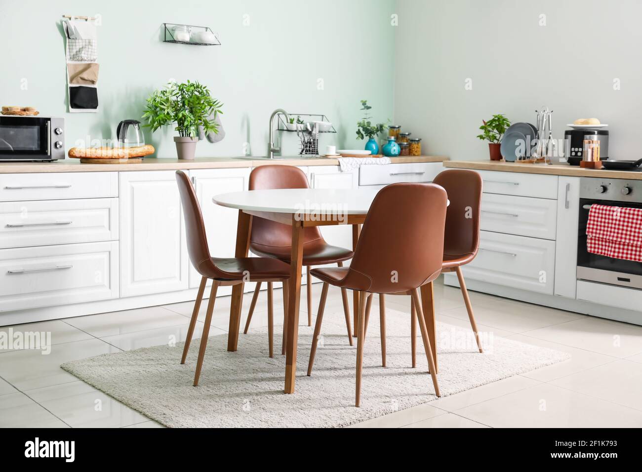 Stylish interior of modern kitchen with dining table Stock Photo - Alamy