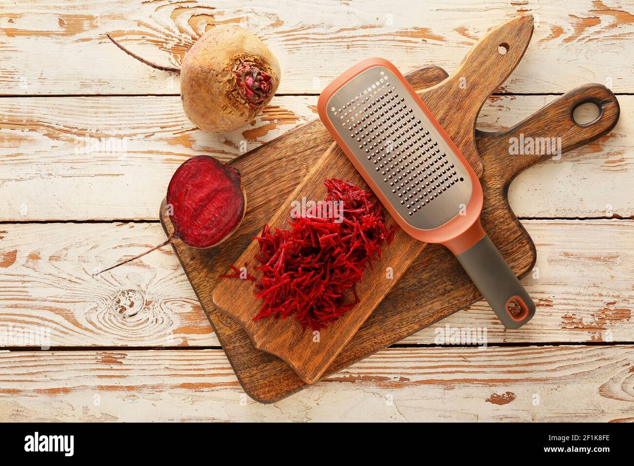 Fresh beetroot and grater on wooden table Stock Photo