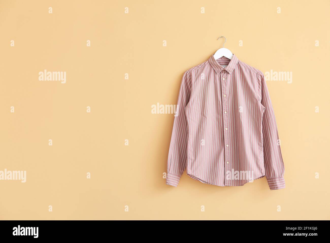 Hanger with shirt on color background Stock Photo
