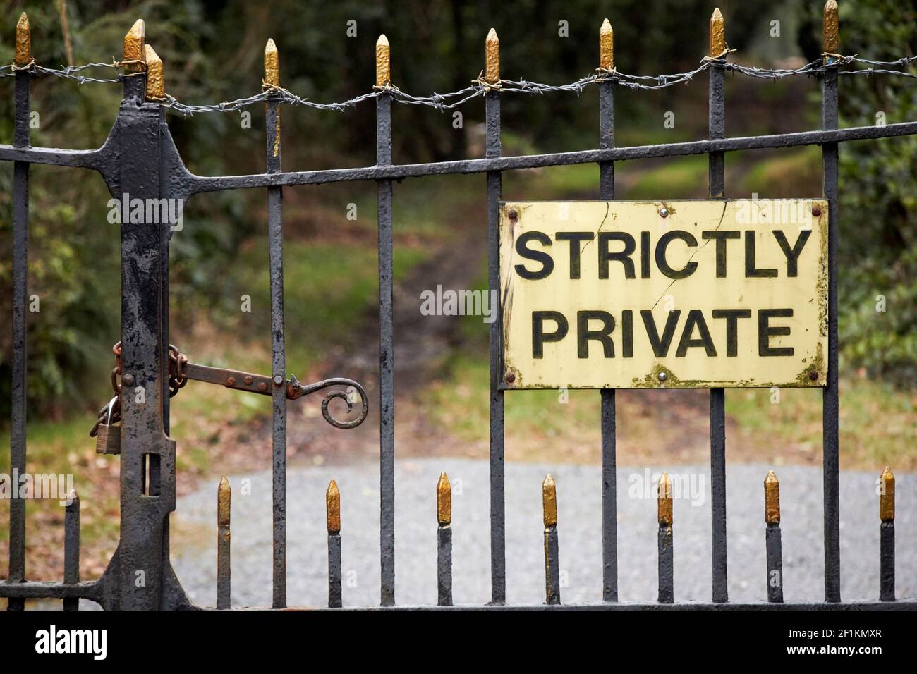 strictly private sign on locked and barbed wire covered metal gate entrance to private property bangor county down northern ireland uk Stock Photo