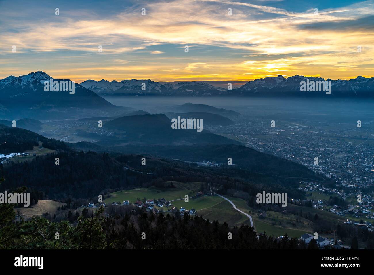 Sonnenuntergang über dem Rheintal. Bodennebel liegt auf Feldkirch und Rankweil. Sunset over the Rhine Valley. Ground fog lies on the city, Vorarlberg Stock Photo