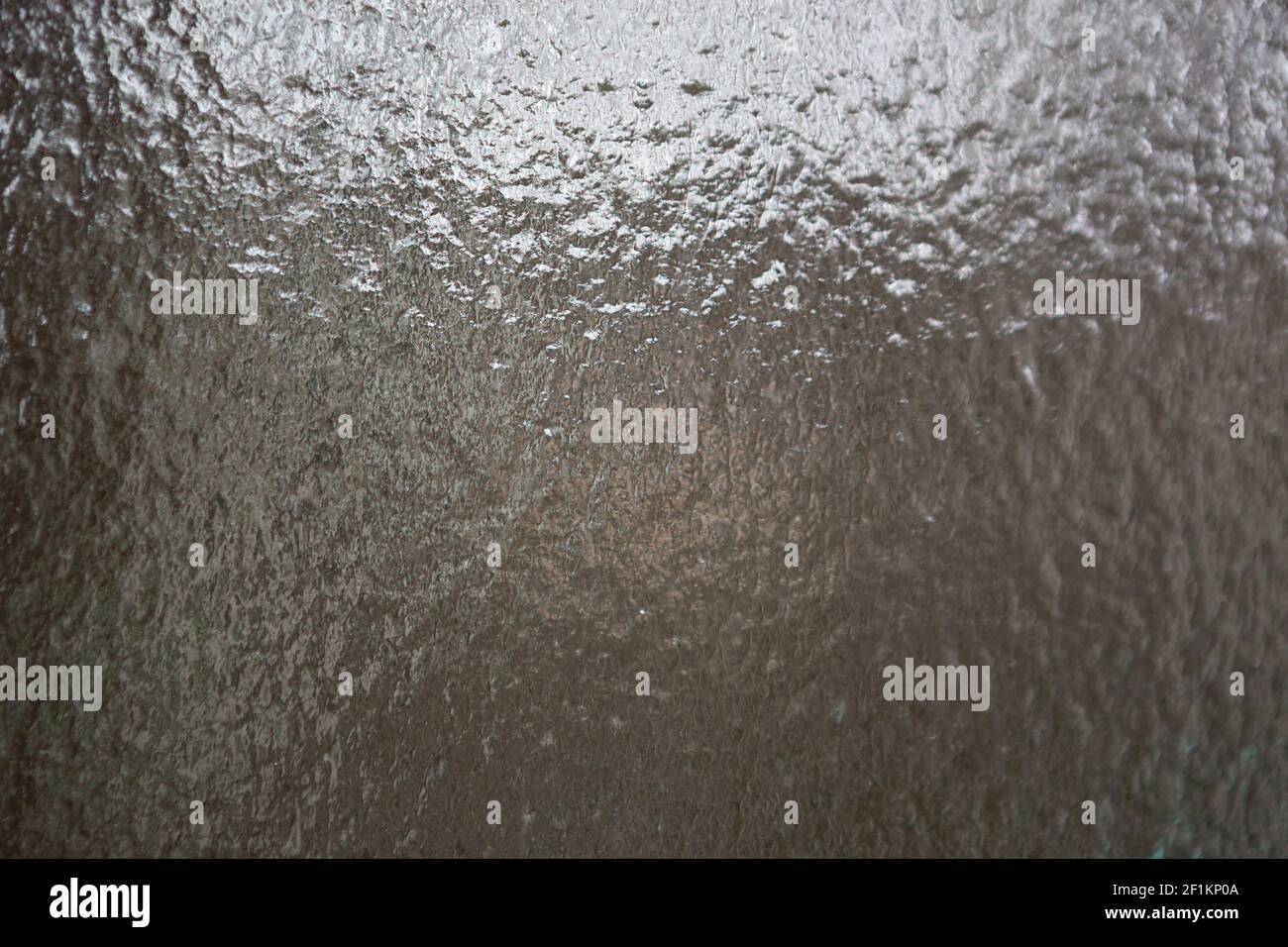Frozen water on the window. Transparent glass with ice is translucent