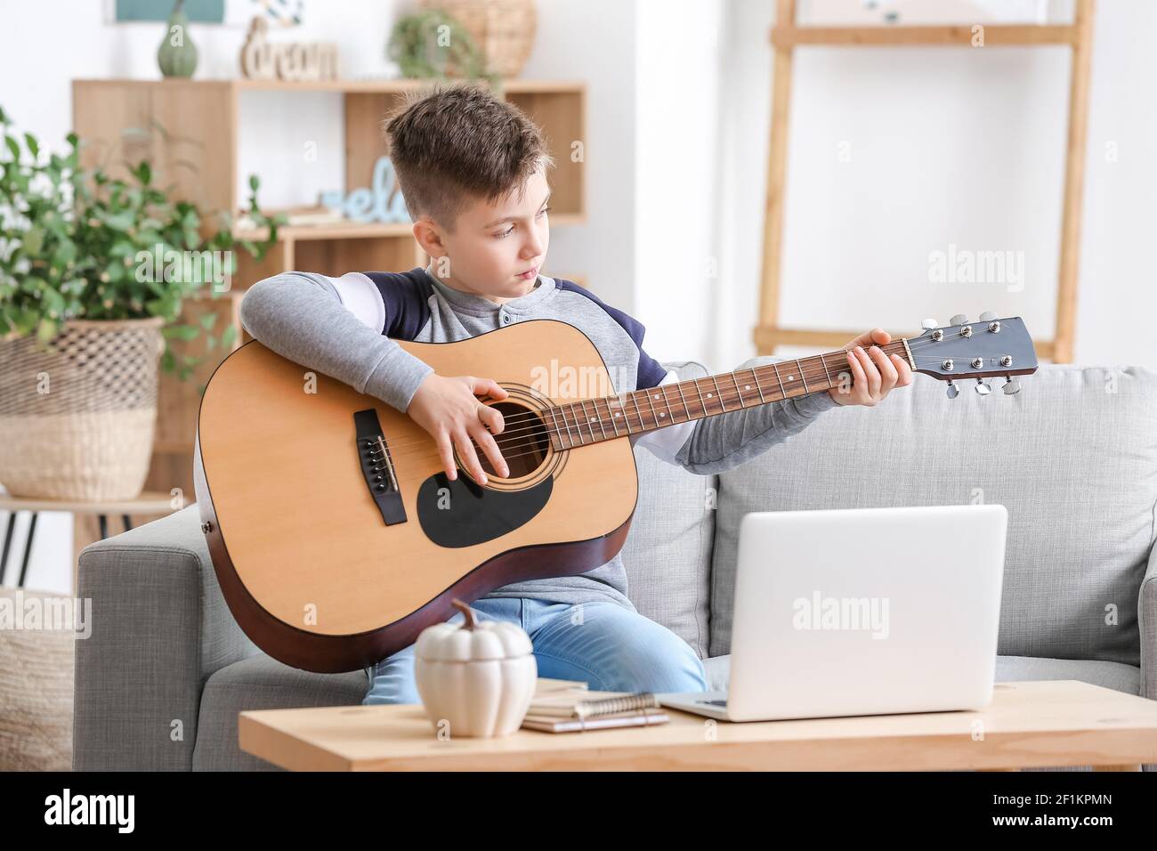 Little boy taking music lessons online at home Stock Photo - Alamy