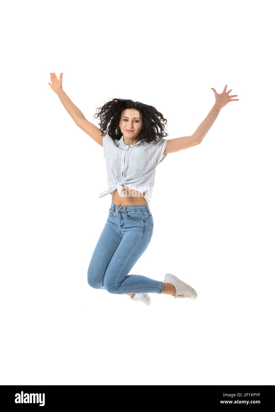 Jumping young woman against white background Stock Photo - Alamy