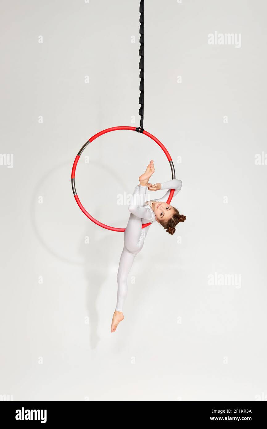 little child girl gymnast doing splits on an aerial hoop Stock Photo
