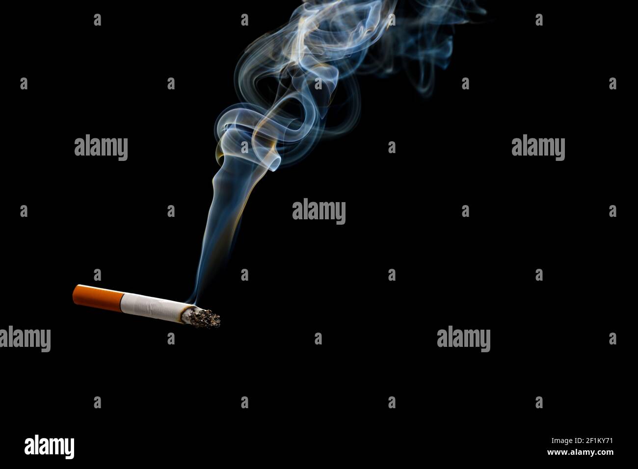 Cigarette with smoke on dark background Stock Photo - Alamy