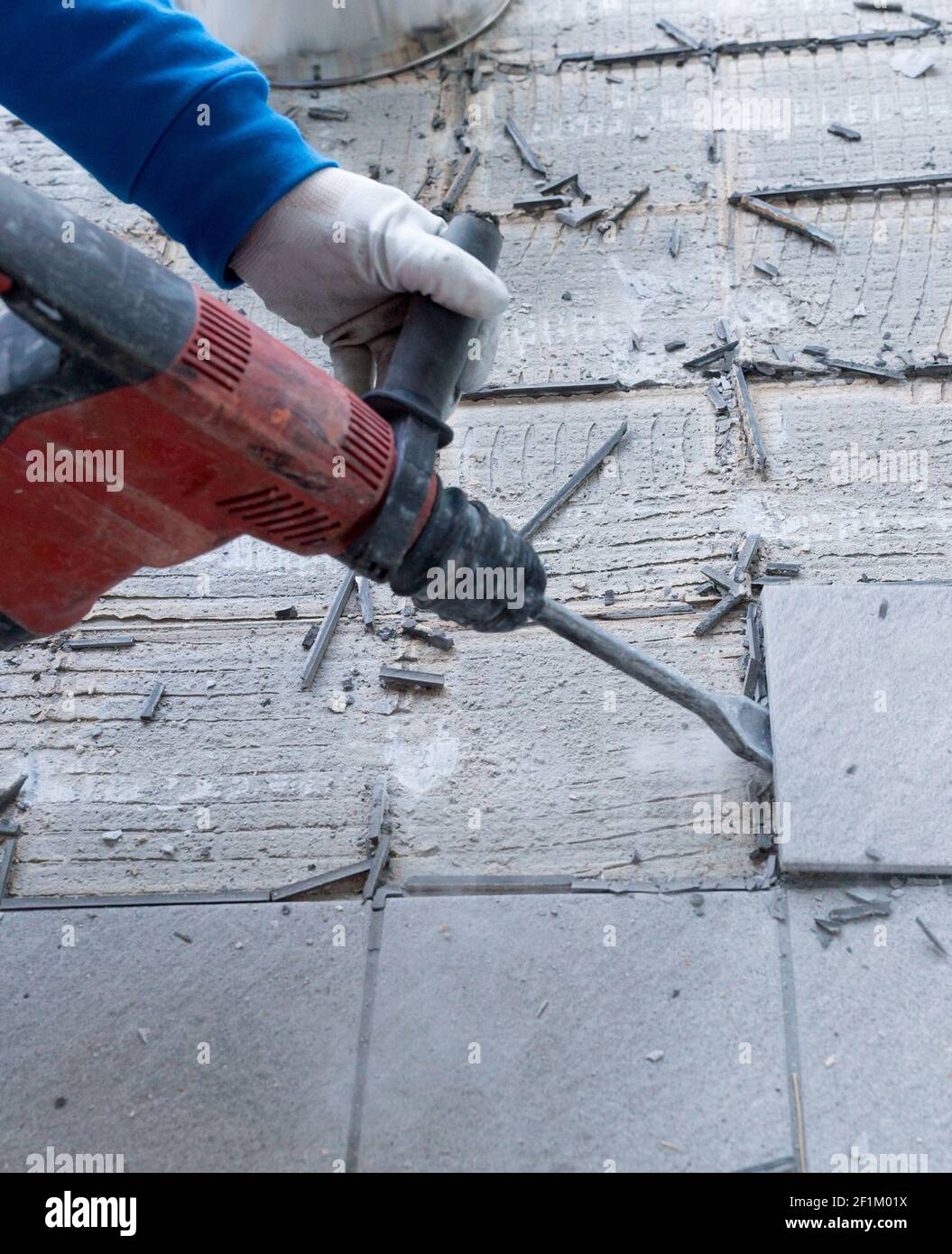 Construction worker using a handheld demolition hammer and wall breaker