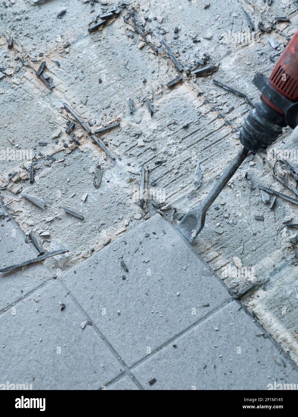 Construction worker using a handheld demolition hammer and wall breaker