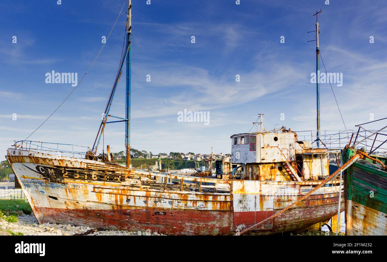 Old fishing boat wrecks stranded and left on a rocky beach Stock Photo ...