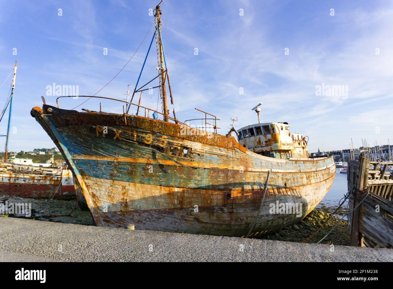 Old fishing boat wrecks stranded and left on a rocky beach Stock Photo ...