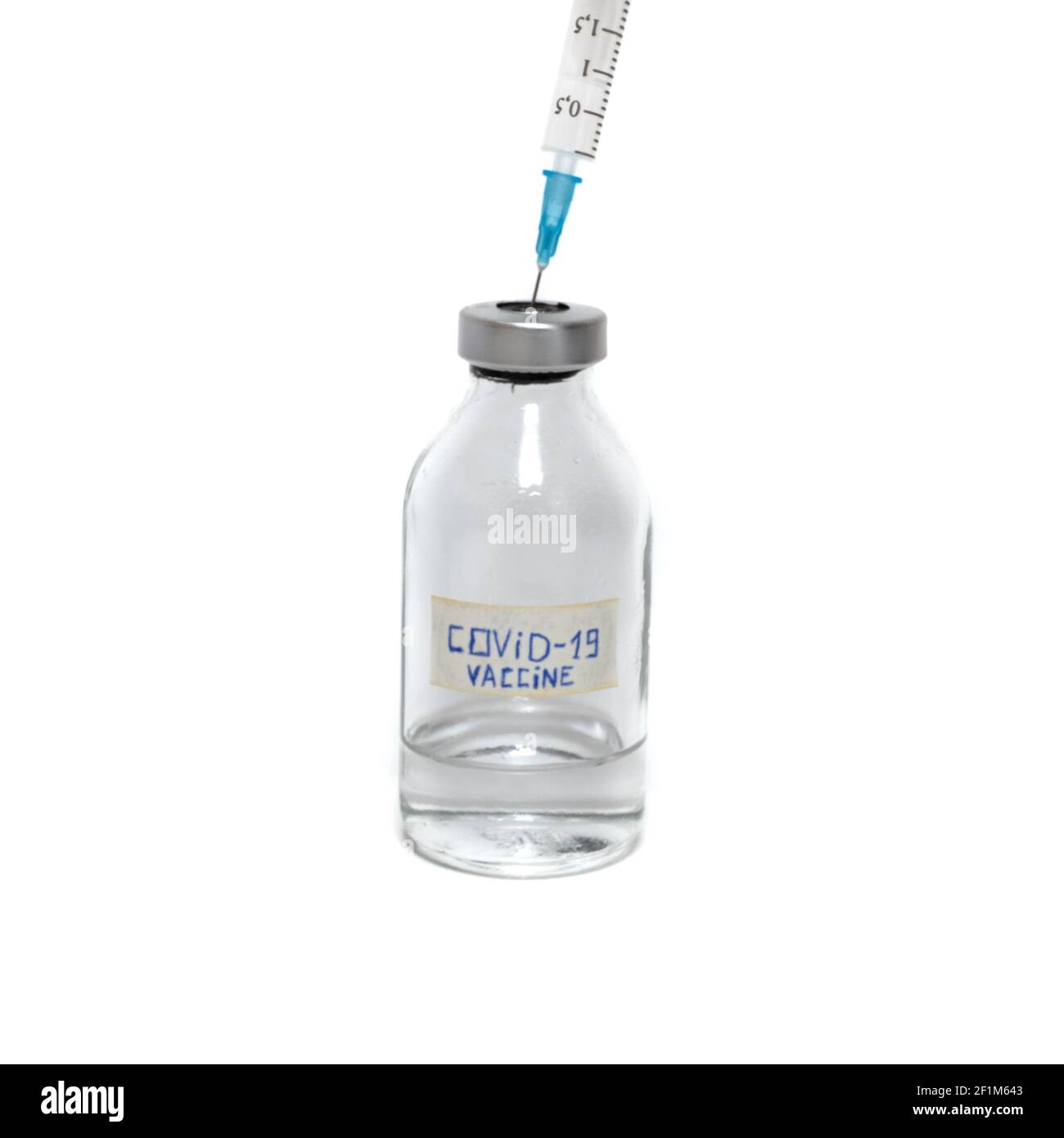 A syringe sticks out in a bottle of vaccine covid-19 Stock Photo