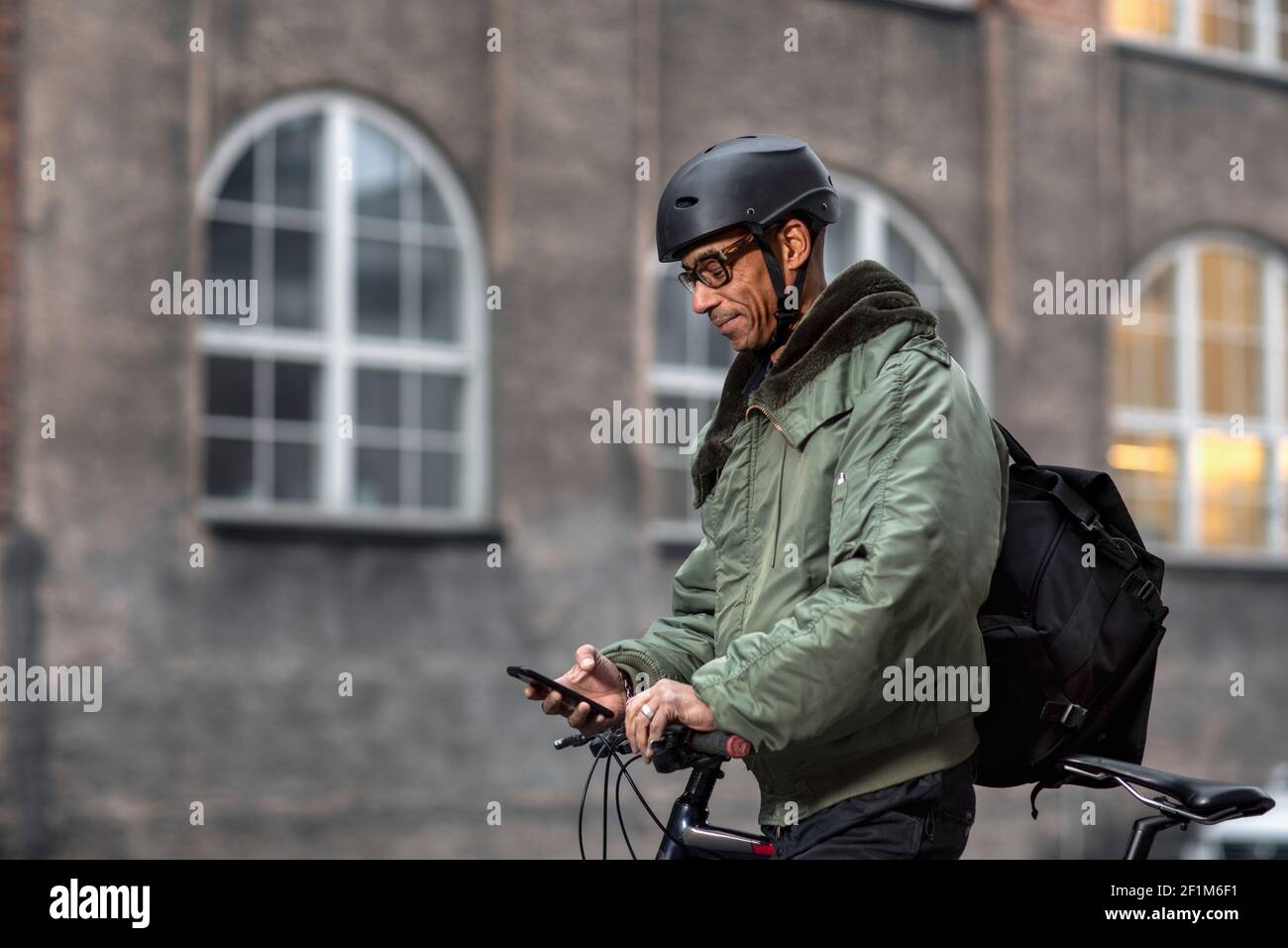 Bicycle courier using cell phone Stock Photo