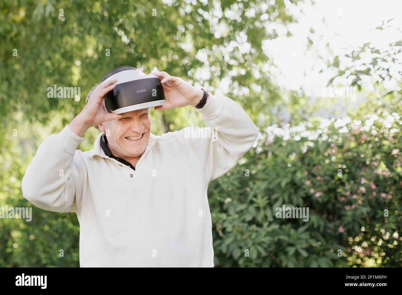 Man in park using VR headset Stock Photo