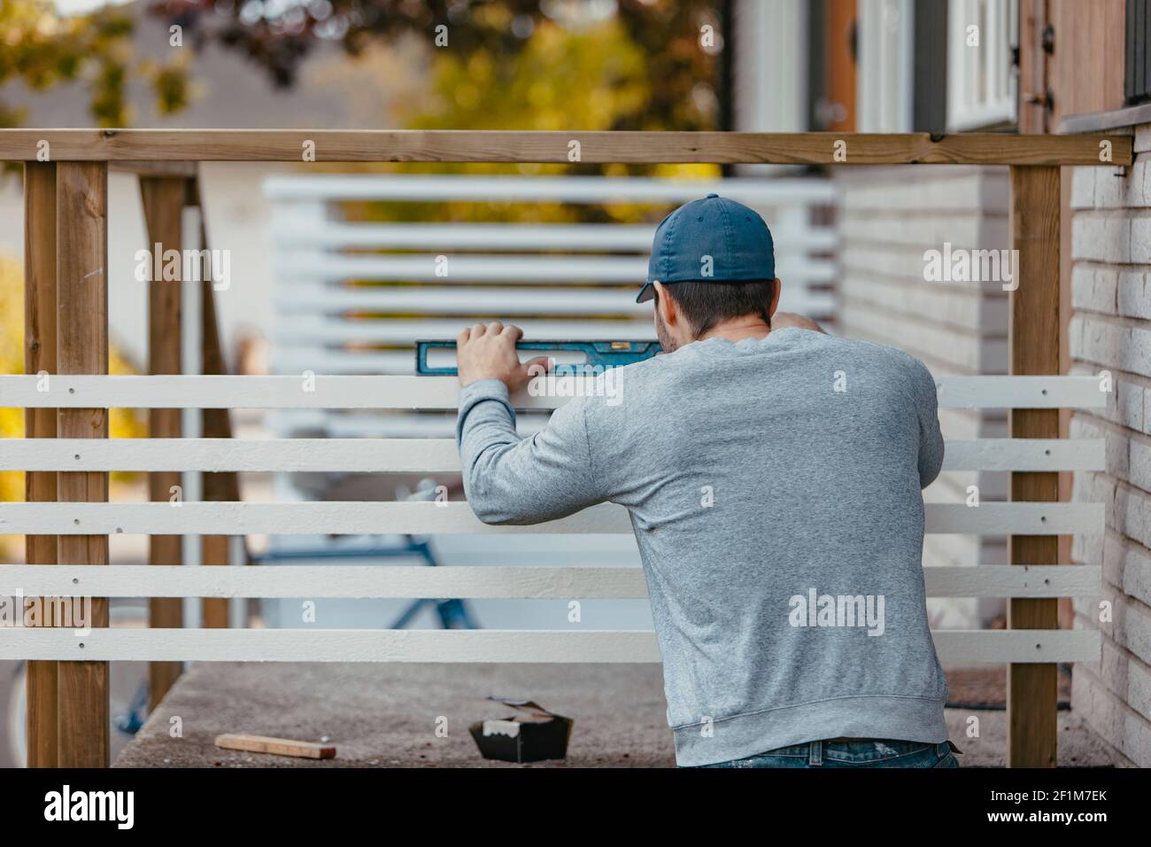 Carpenter using spirit level on patio railing Stock Photo